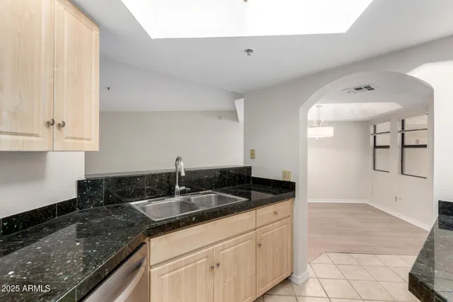 a kitchen with granite countertop white cabinets and sink