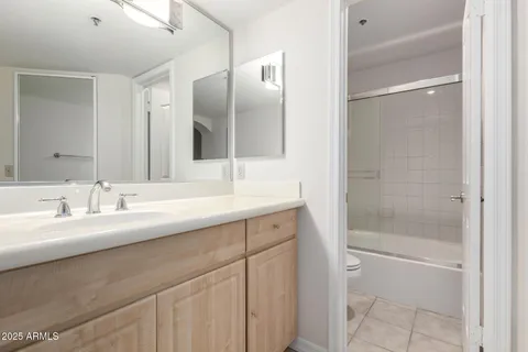 a bathroom with a double vanity sink mirror and shower