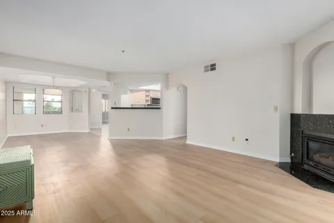 a view of empty room with wooden floor and fireplace