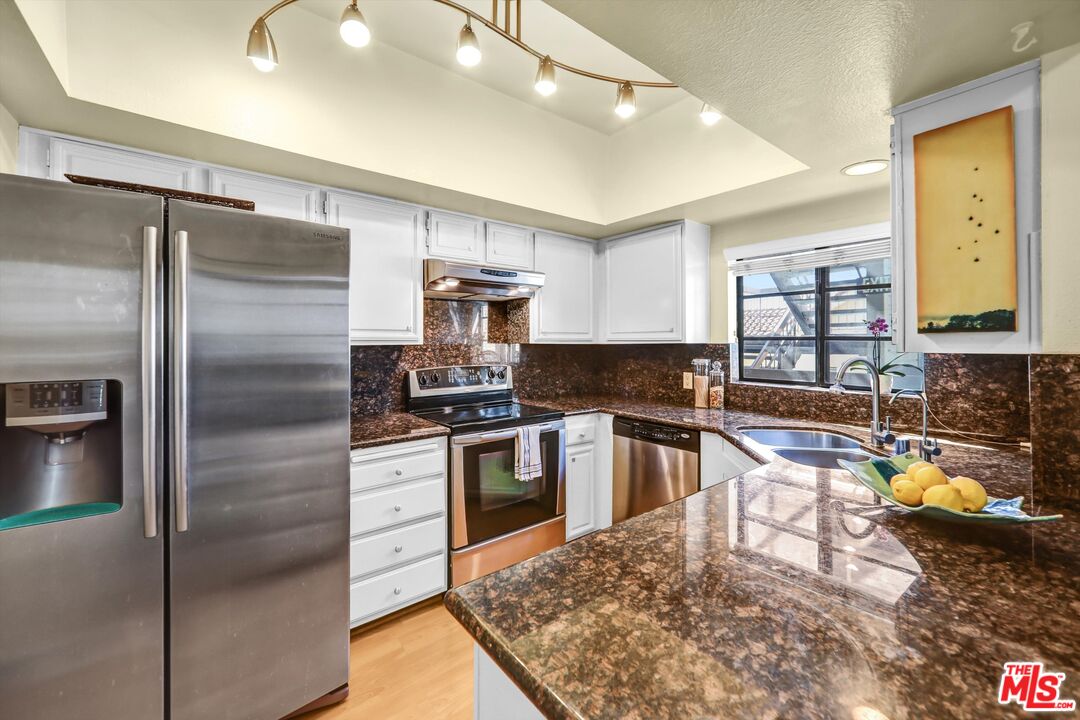 1313 Valley View Road, Unit 213 Glendale, CA 91202 - Photo 14 of 31 a kitchen with kitchen island a counter top space a sink stainless steel appliances and cabinets