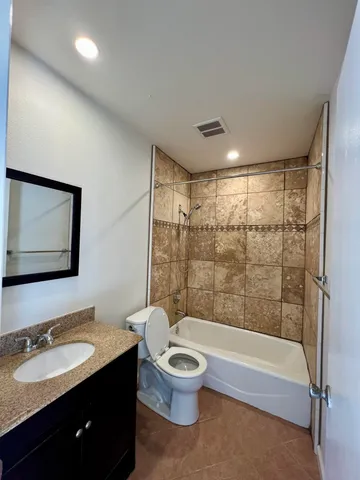 a bathroom with a toilet a sink a mirror a bathtub and shower