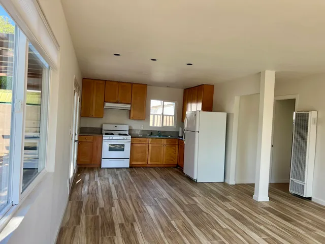 a kitchen with a refrigerator and wooden floor