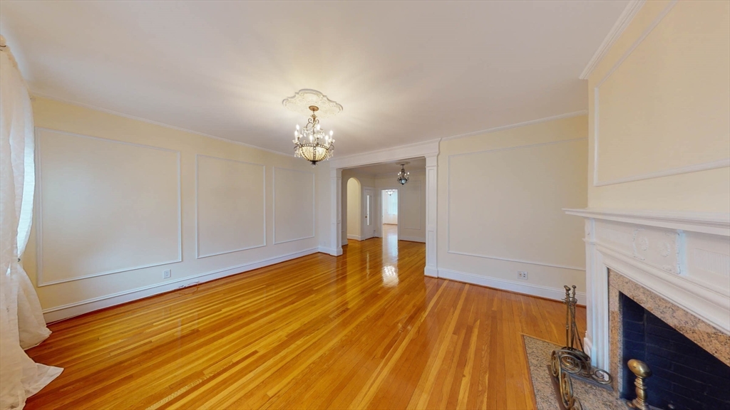 311 Tappan Street, Unit 3 Brookline, MA 02445 - Photo 8 of 35 a view of empty room with wooden floor and fireplace