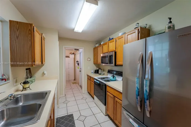 a kitchen with granite countertop a refrigerator stove and sink
