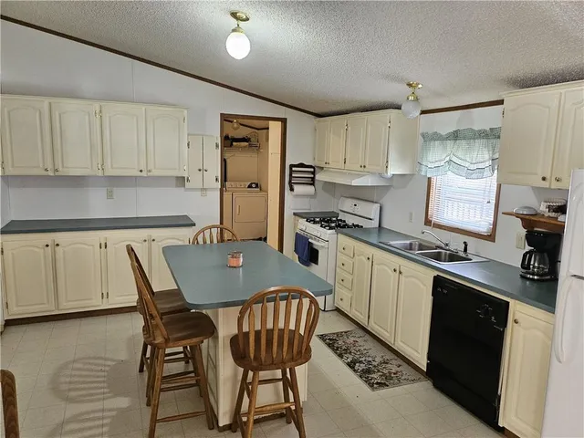 a kitchen with stainless steel appliances a dining table chairs and stove