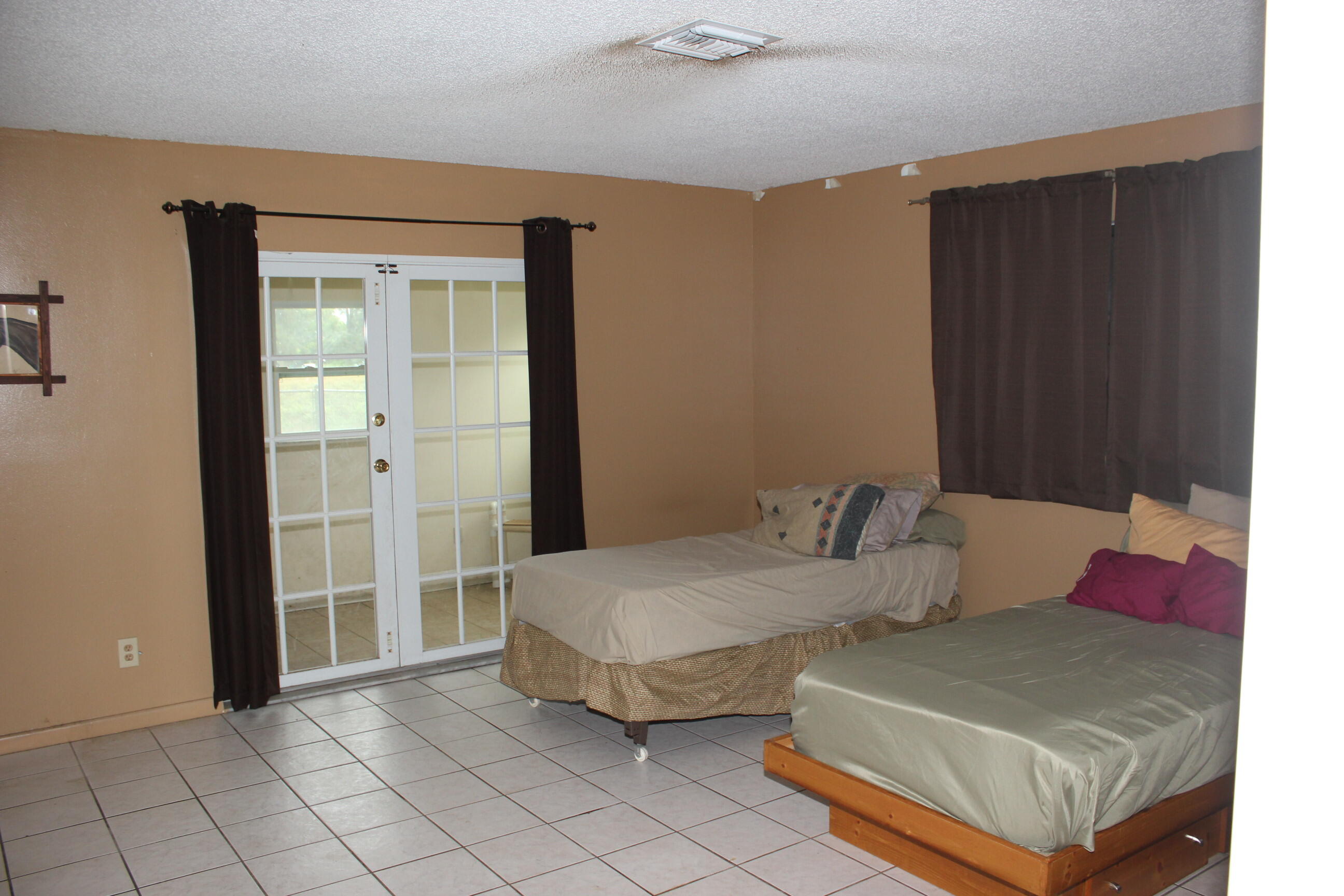 4981 Serafica Drive Lake Worth, FL 33461 - Photo 30 of 44 a bedroom with bed and a window