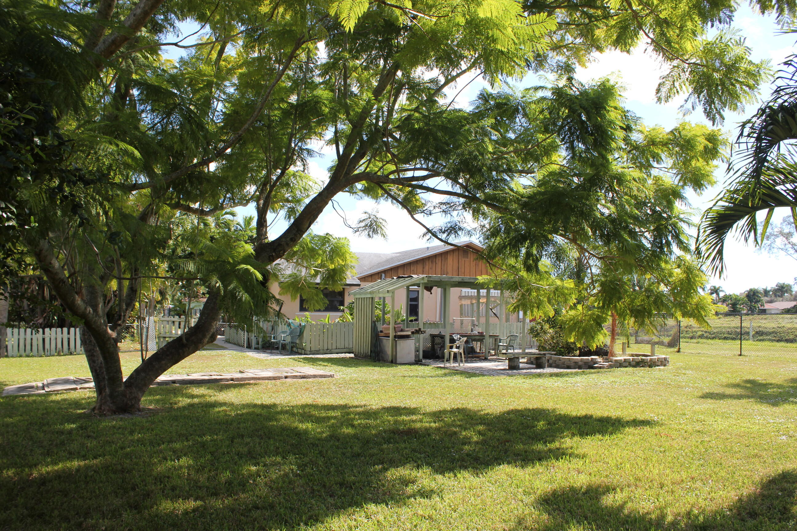 4981 Serafica Drive Lake Worth, FL 33461 - Photo 41 of 44 a view of swimming pool and trees in the background