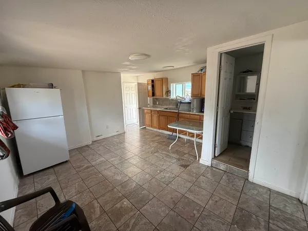 a room with a furniture and a refrigerator