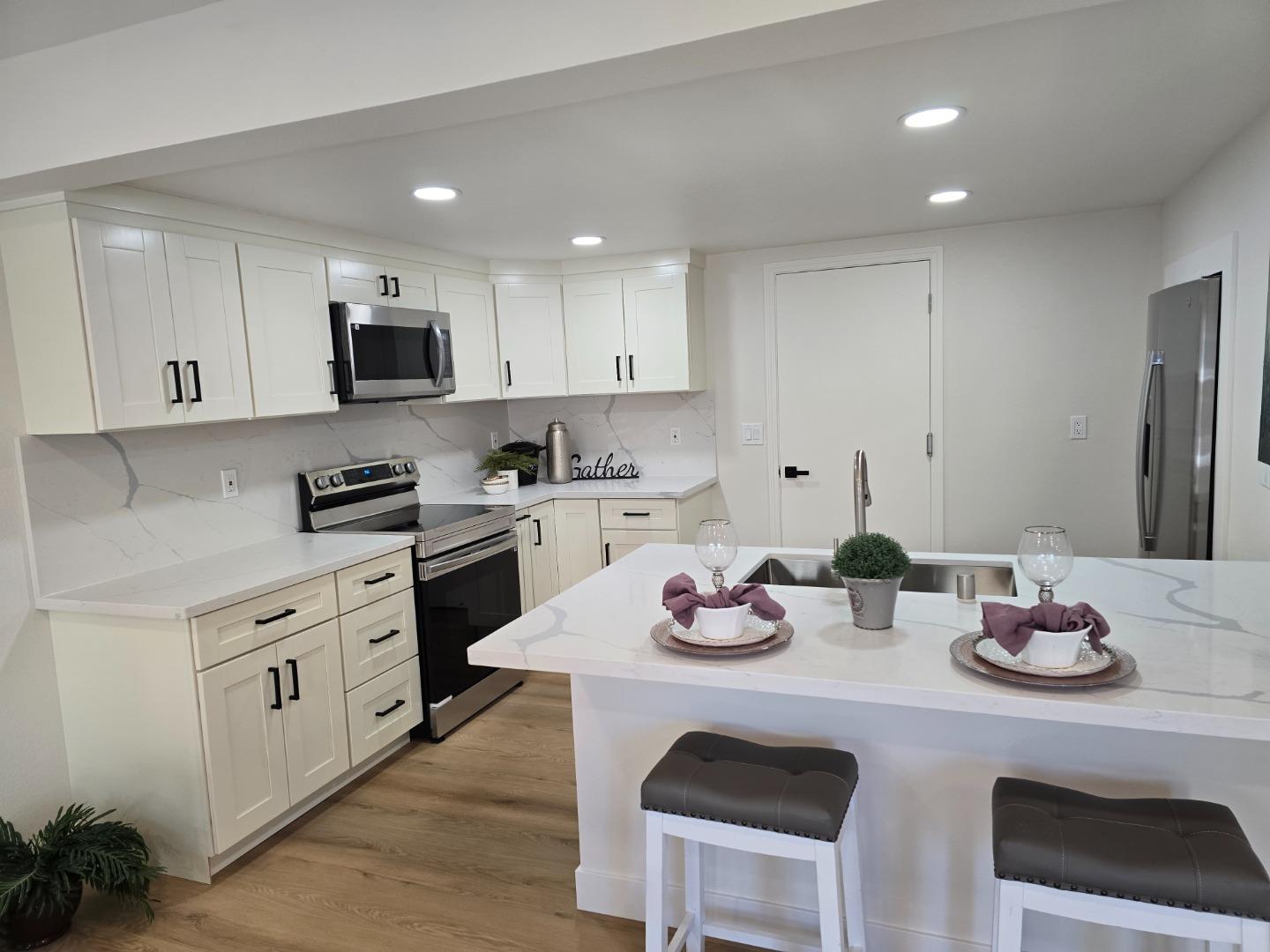 3575 Lehigh Drive, Unit 25 Santa Clara, CA 95051 - Photo 7 of 29 a kitchen with sink a stove and white cabinets with wooden floor