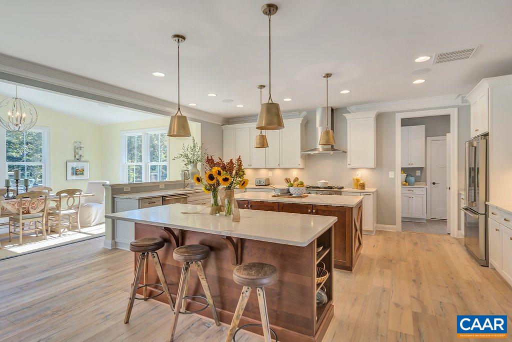 2134 Ridgetop Drive Charlottesville, VA 22903 - Photo 15 of 49 a kitchen with stainless steel appliances kitchen island granite countertop a table chairs and a refrigerator