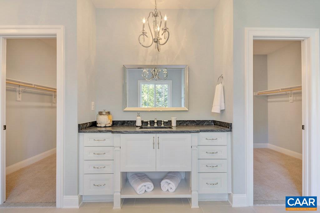 2134 Ridgetop Drive Charlottesville, VA 22903 - Photo 32 of 49 a bathroom with a granite countertop sink mirror vanity and a bathtub
