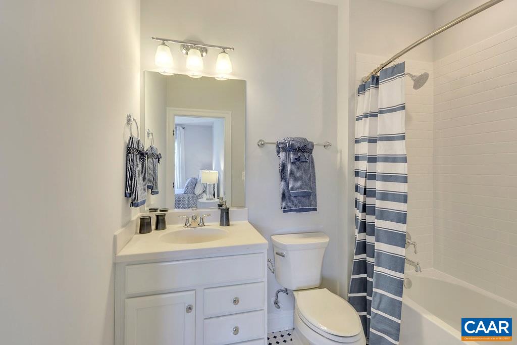 2134 Ridgetop Drive Charlottesville, VA 22903 - Photo 39 of 49 a bathroom with a sink a toilet a mirror and shower curtain