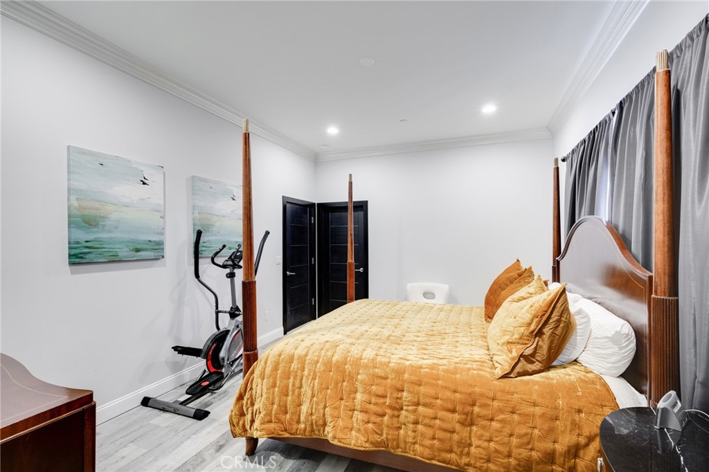 10461 Hillhaven Avenue Tujunga, CA 91042 - Photo 11 of 31 a bedroom with a bed and wooden floor