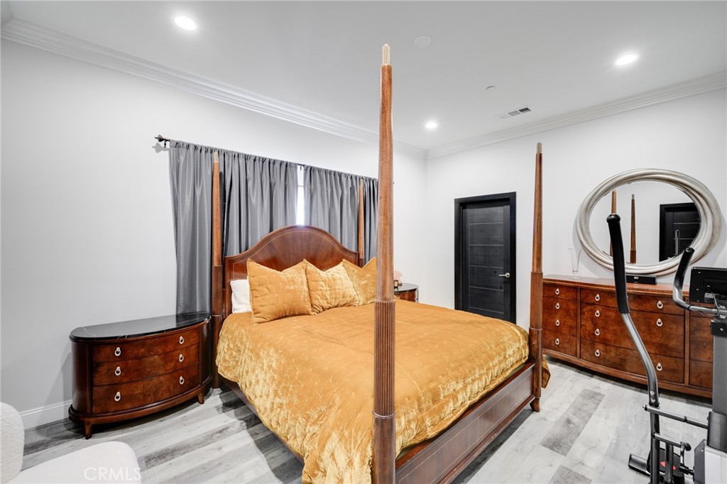 10461 Hillhaven Avenue Tujunga, CA 91042 - Photo 10 of 31 a bedroom with a bed and dresser with mirror