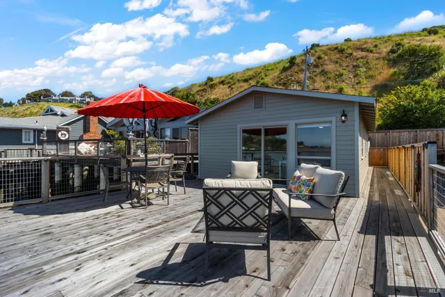 a patio with a table and chairs under an umbrella