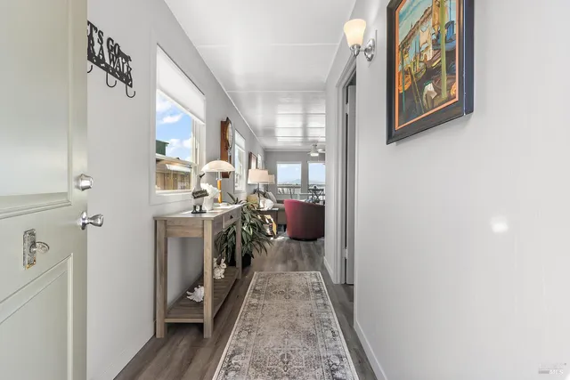 a view of a hallway to a livingroom with furniture