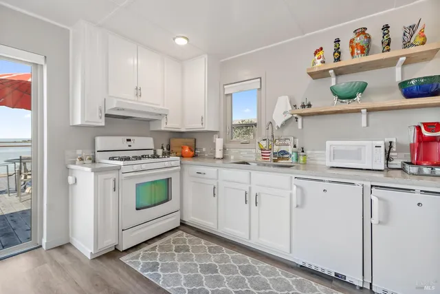 a kitchen with stainless steel appliances granite countertop a sink a stove a refrigerator and cabinets