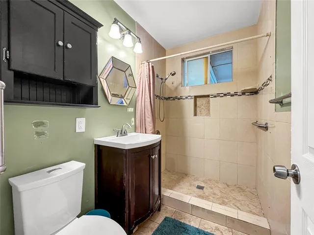 a bathroom with a sink a toilet and shower