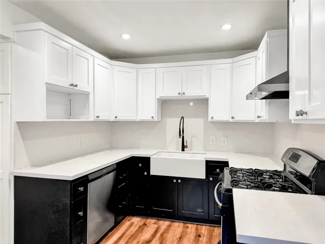 a kitchen with white cabinets appliances and sink
