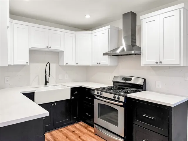 a kitchen with stainless steel appliances a sink stove and cabinets