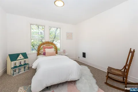 a bedroom with a bed a window and chair