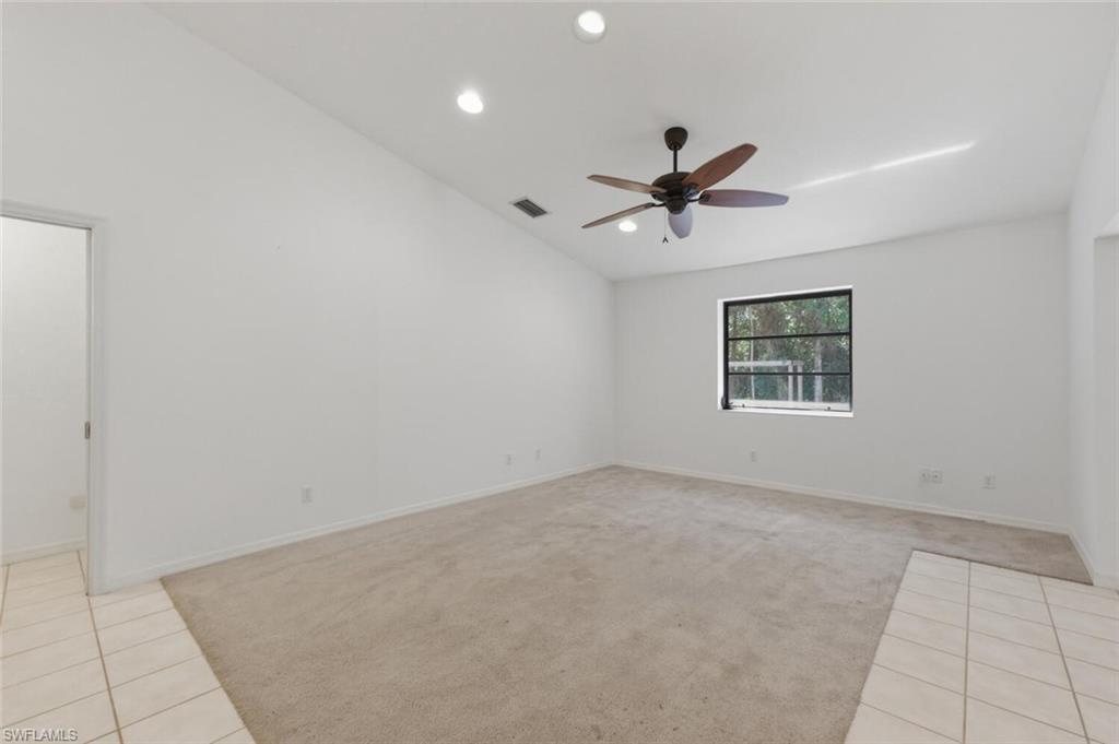 5356 Sycamore Drive Naples, FL 34119 - Photo 11 of 20 an empty room with chandelier fan and windows