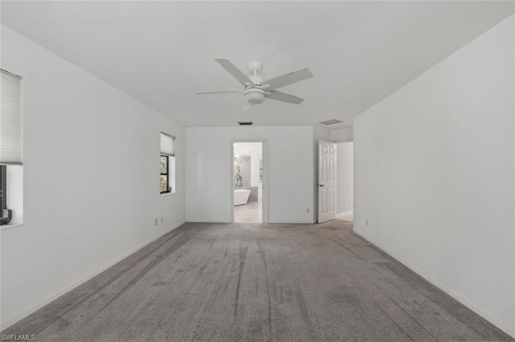 5356 Sycamore Drive Naples, FL 34119 - Photo 14 of 20 an empty room with an entryway and fan