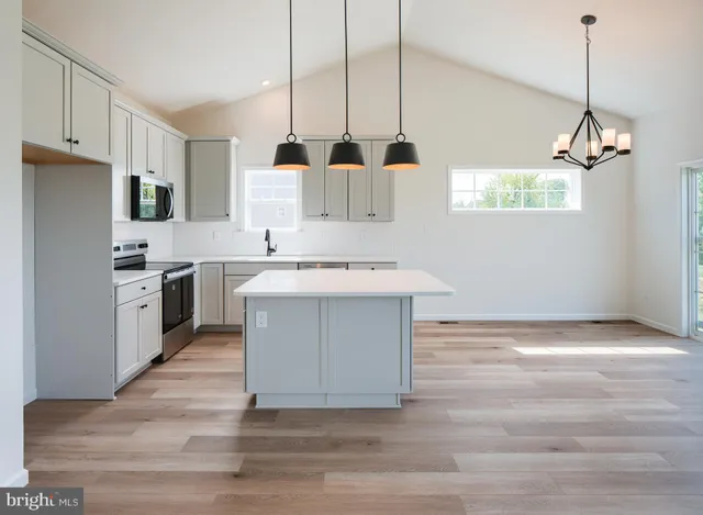 a view of a room with wooden floor ceiling fan and window