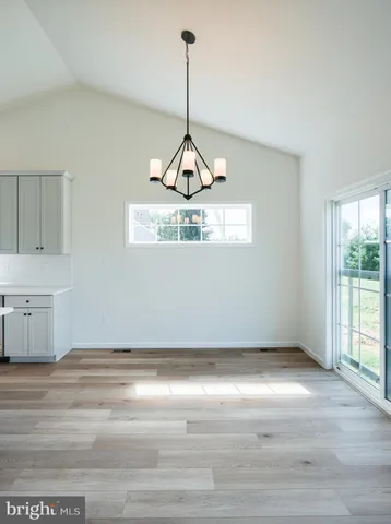 a kitchen with stainless steel appliances white cabinets a sink a stove a kitchen island and chairs
