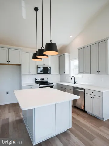 a view of a room with wooden floor and a ceiling fan