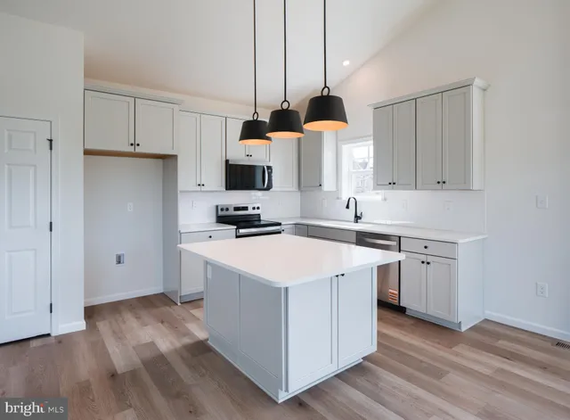 a kitchen with a sink white cabinets and white appliances