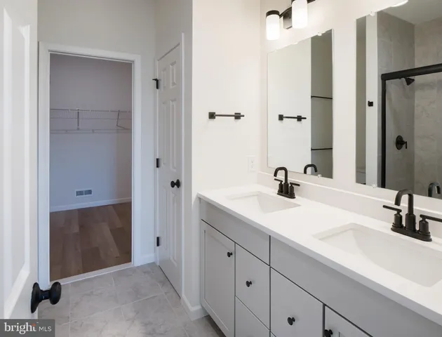 a bathroom with a double vanity sink a mirror and shower