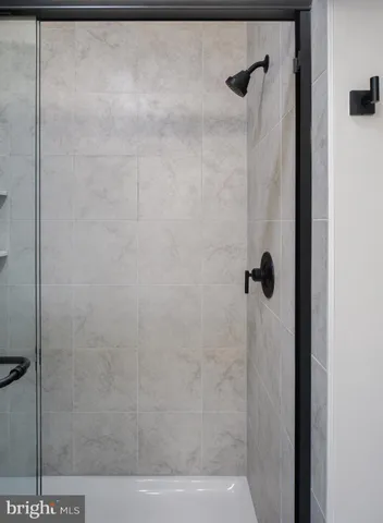 an empty room with wooden floor chandelier fan and windows