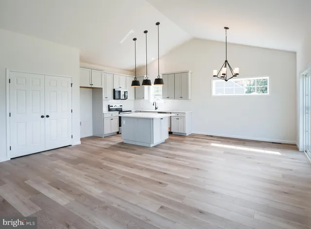 a view of a hallway with wooden floor and windows