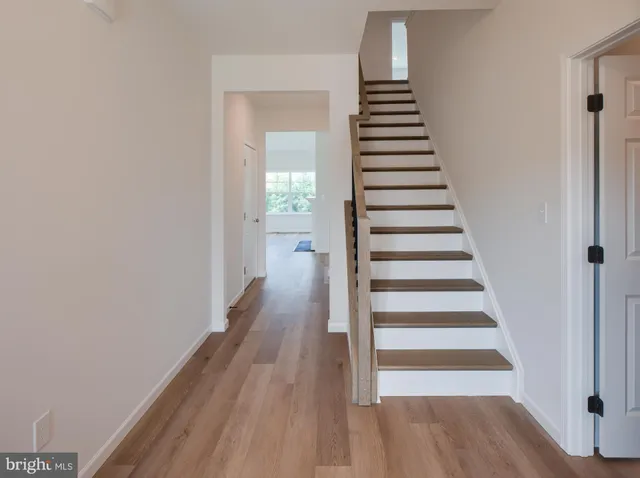 a view of staircase with wooden floor and white walls