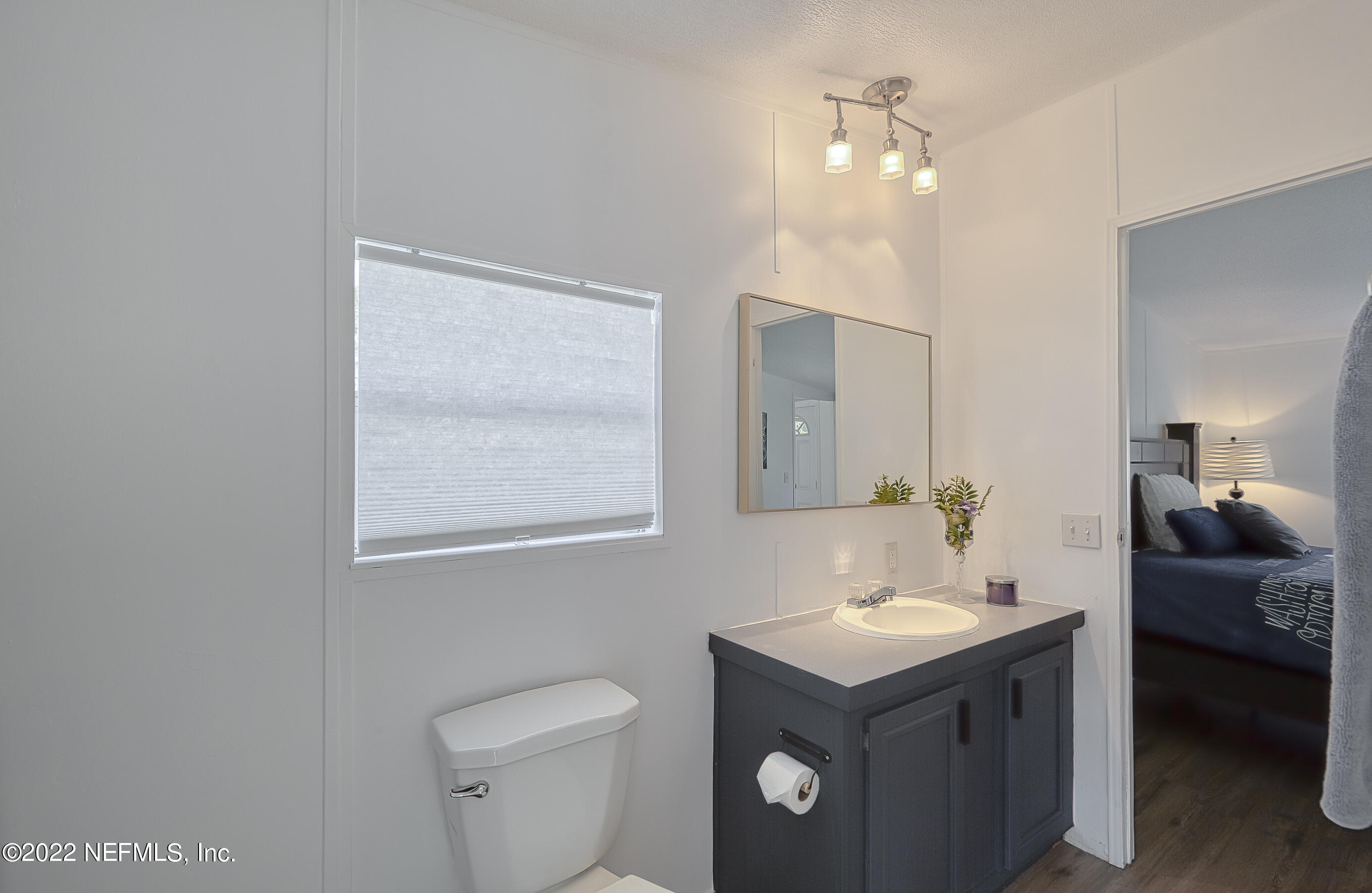4509 De Leon Place St. Augustine, FL 32095 - Photo 14 of 35 a bathroom with a toilet sink vanity and mirror