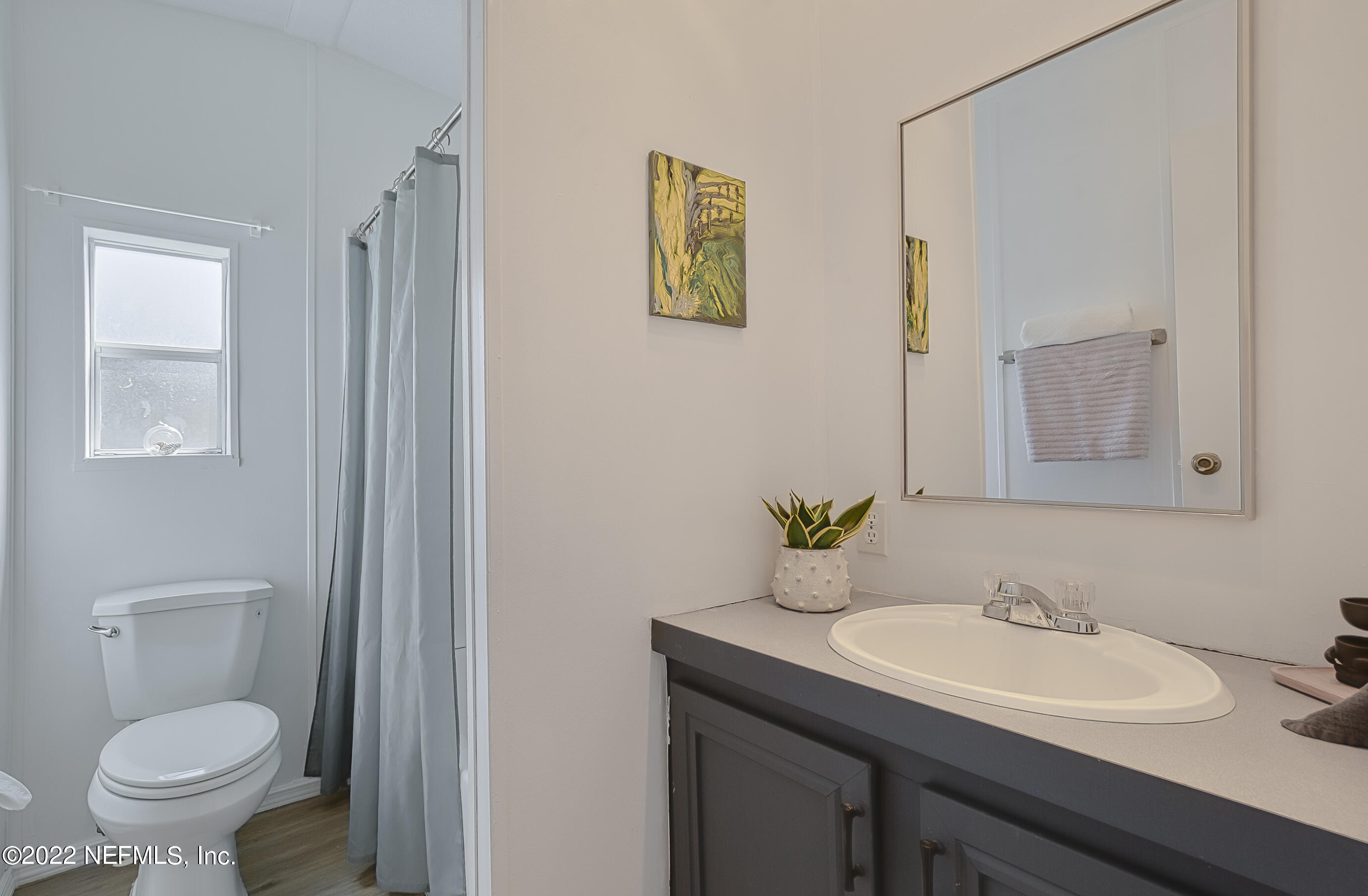 4509 De Leon Place St. Augustine, FL 32095 - Photo 20 of 35 a bathroom with a granite countertop sink a toilet and a mirror