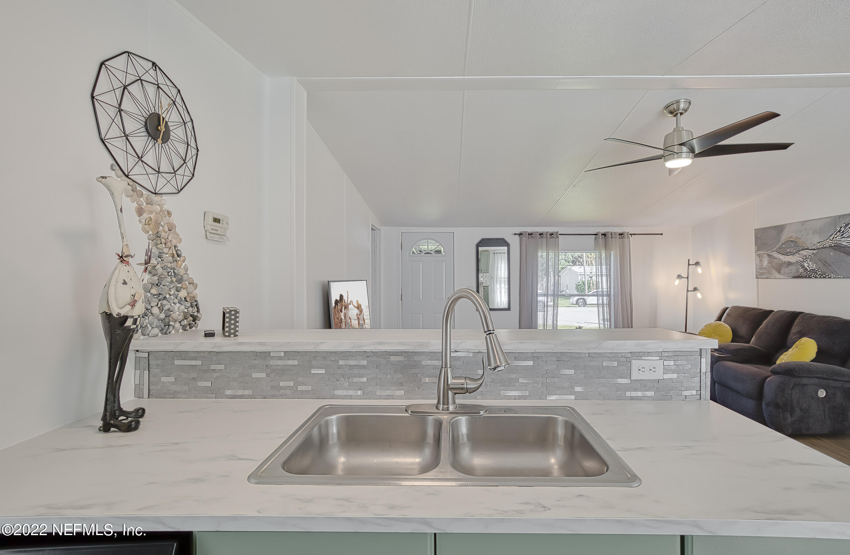 4509 De Leon Place St. Augustine, FL 32095 - Photo 7 of 35 a kitchen with a sink and a clock on the wall