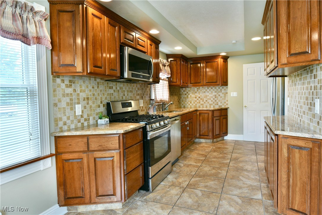 1735 Pleasant Valley Road Girard, OH 44420 - Photo 9 of 44 Kitchen with stainless steel appliances, brown cabinetry, healthy amount of natural light, tasteful backsplash, and recessed lighting