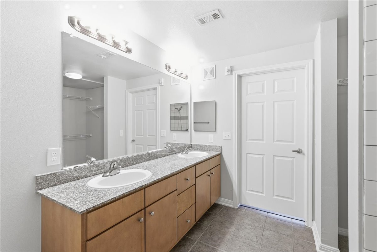 2502 Leon Street, Unit 414 Austin, TX 78705 - Photo 13 of 21 a bathroom with a granite countertop sink and a mirror