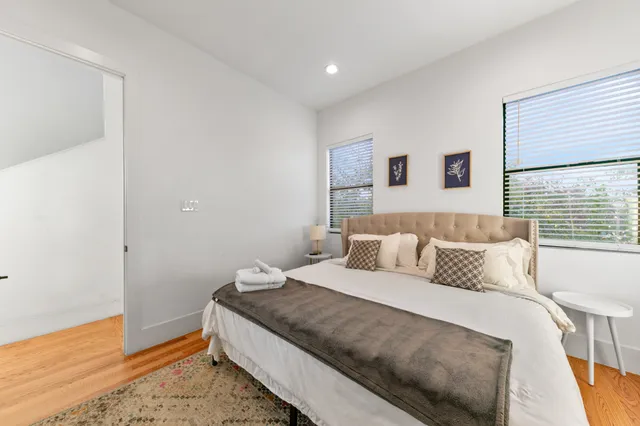 a bedroom with a bed and hardwood floor