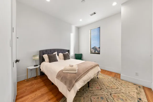 a bedroom with bed and wooden floor
