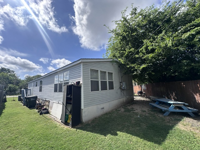 106 Ramirez Street Kyle, TX 78640 - Photo 5 of 19 A pleasant backyard offers green lawn space and mature shade trees.