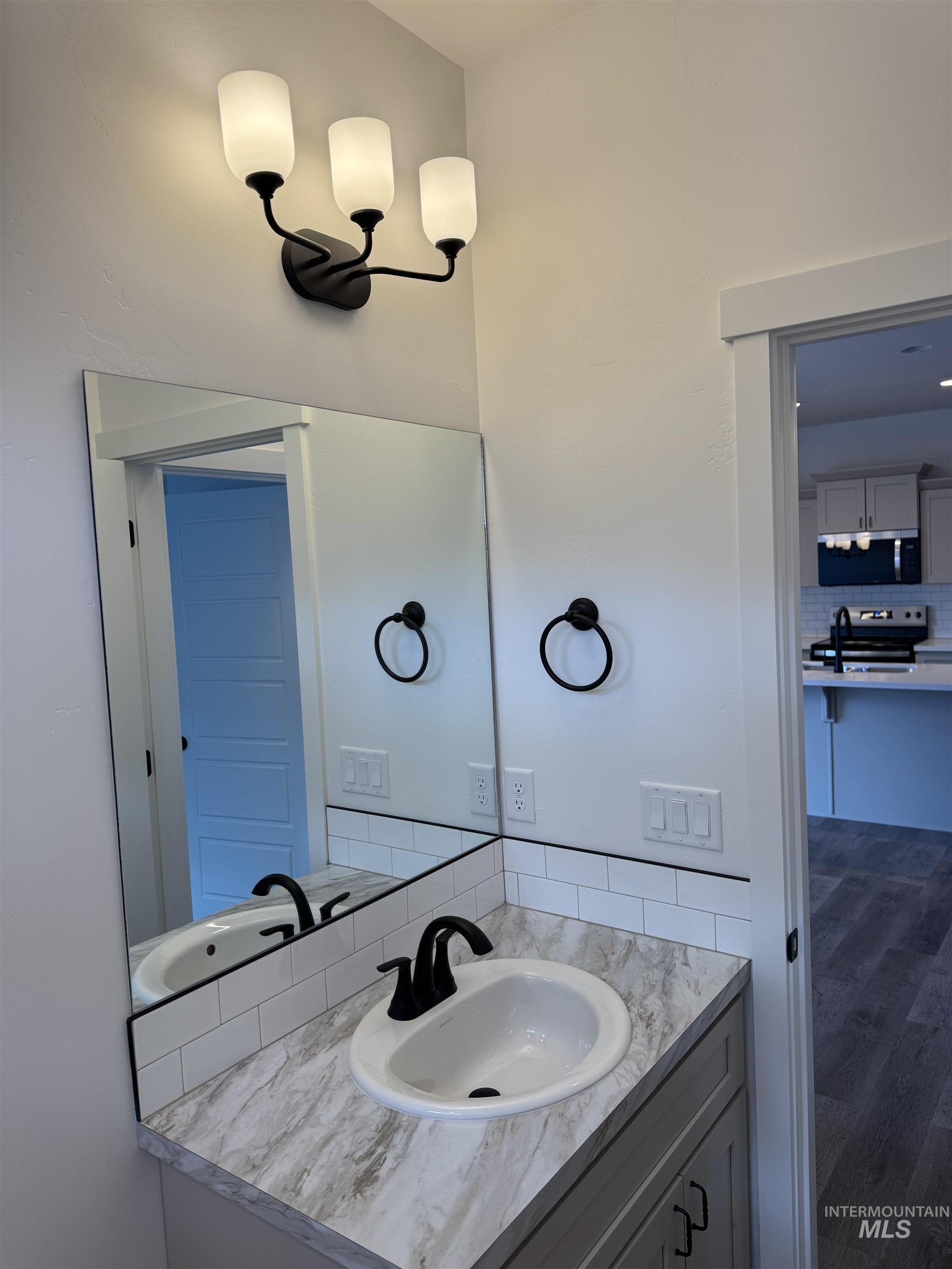 2008 Harrison Street South Twin Falls, ID 83301 - Photo 26 of 32 Bathroom with vanity, decorative backsplash, and dark wood-type flooring