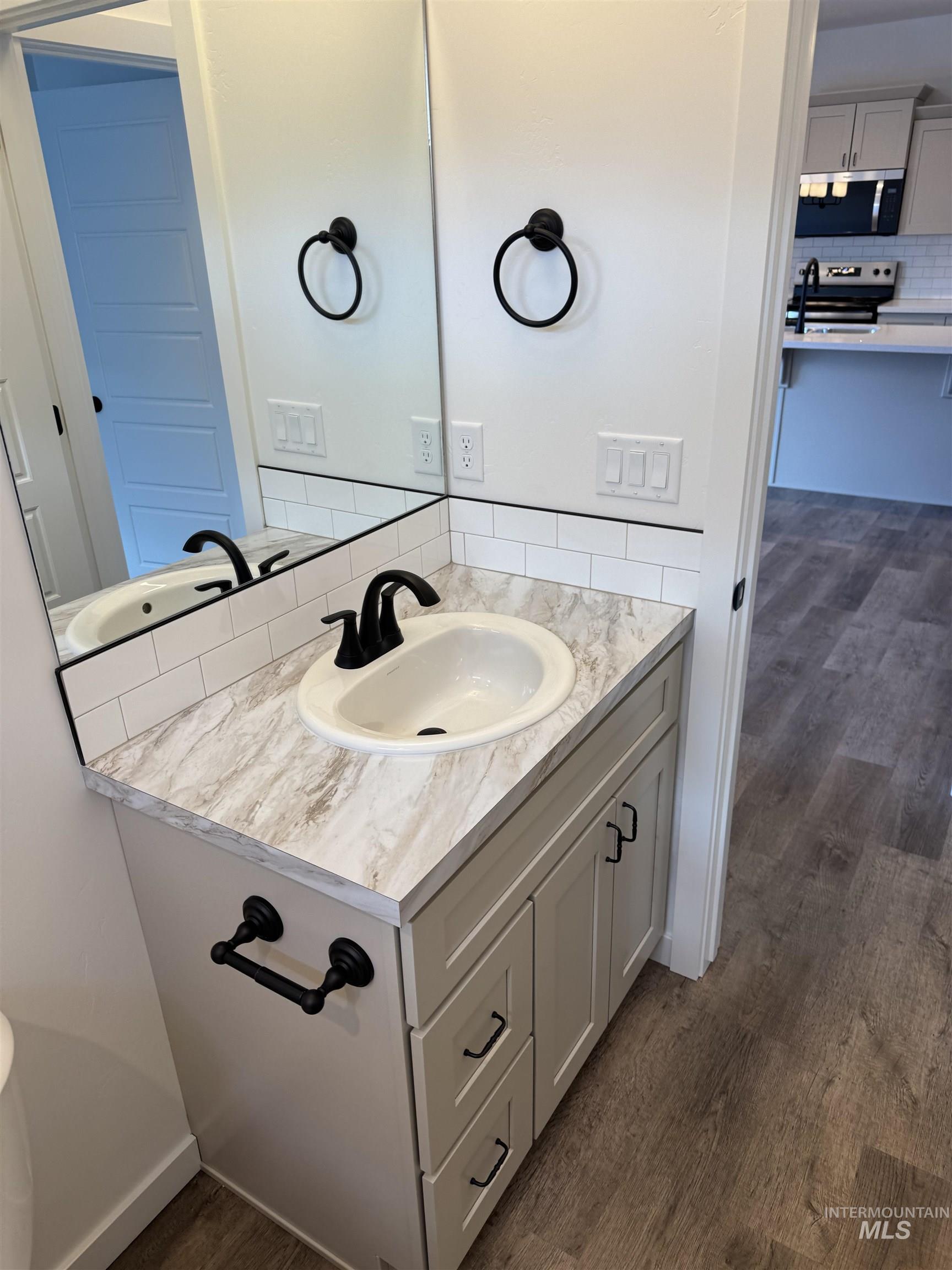 2008 Harrison Street South Twin Falls, ID 83301 - Photo 27 of 32 Bathroom with backsplash, vanity, and dark wood-type flooring