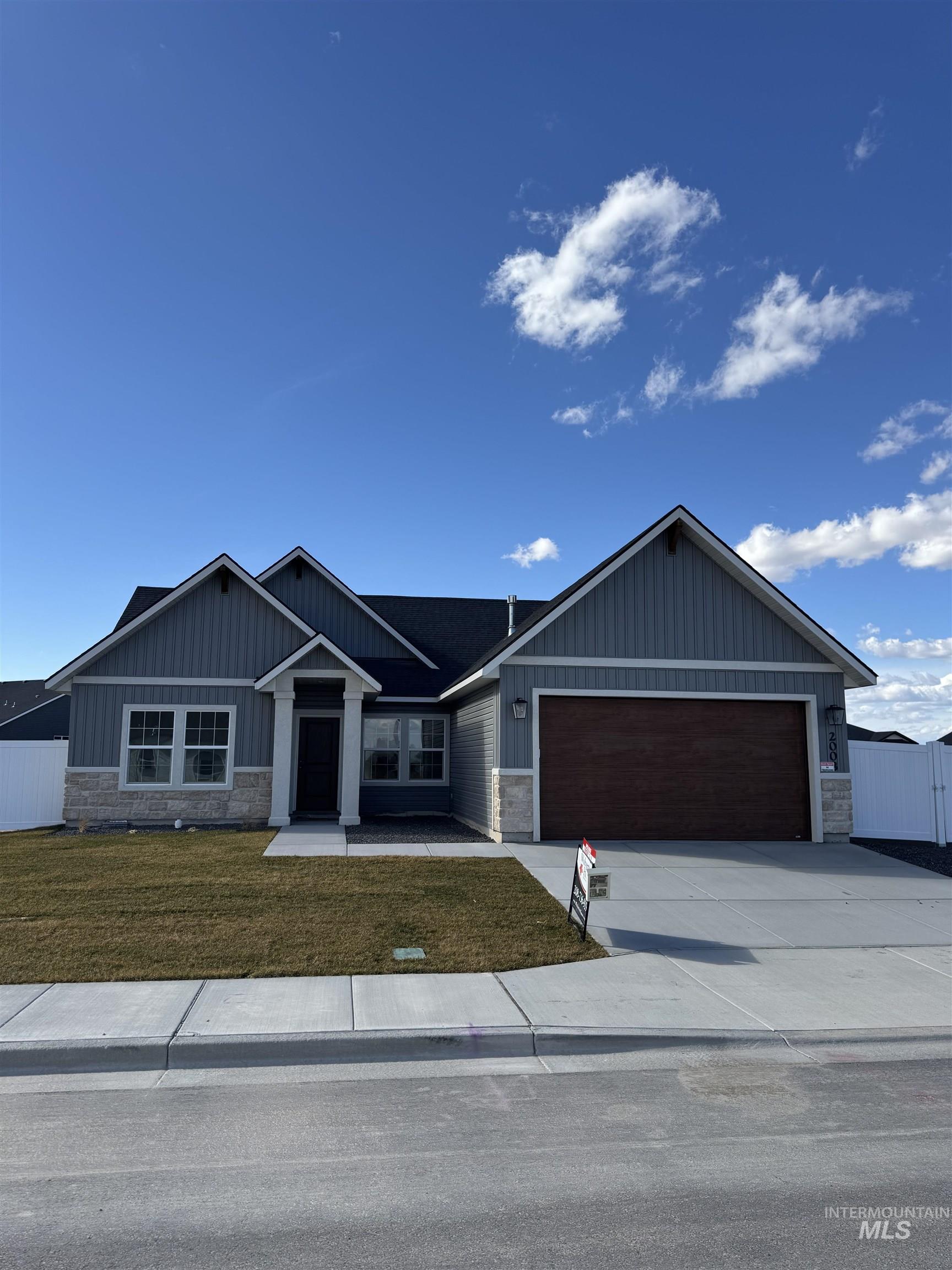 2008 Harrison Street South Twin Falls, ID 83301 - Photo 30 of 32 View of front of home featuring board and batten siding, driveway, a garage, stone siding, and a front lawn