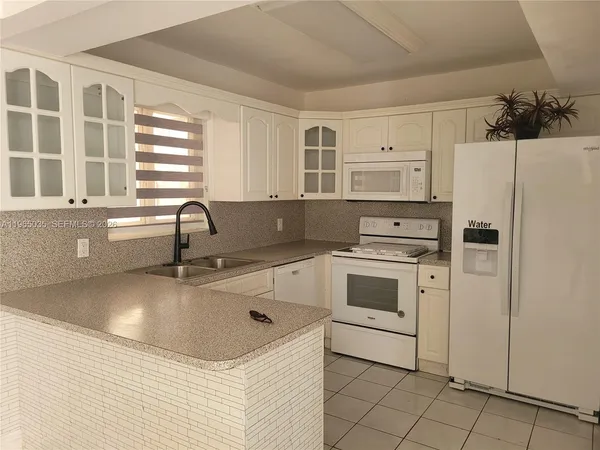 a kitchen with stainless steel appliances a refrigerator sink and cabinets