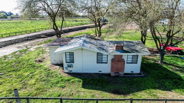 front view of house with a yard and potted plants