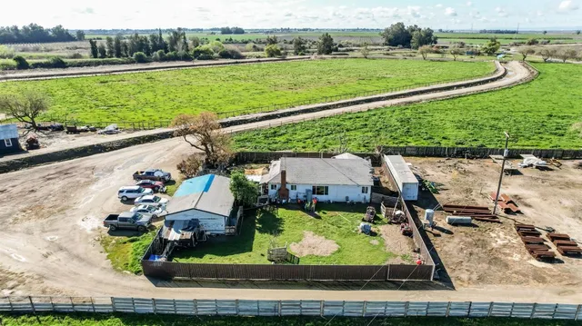 an aerial view of a house with a garden and lake view