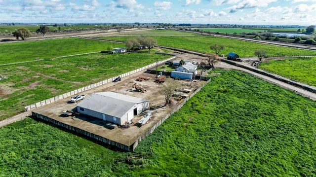 an aerial view of a house with a yard and lake view